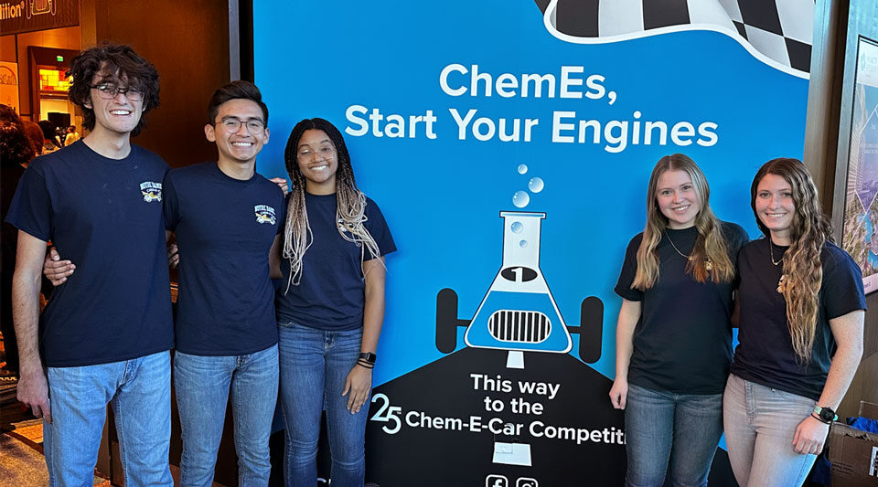 Notre Dame Chem-E-Car team in front of AIChE Chem-E-Car Competition sign