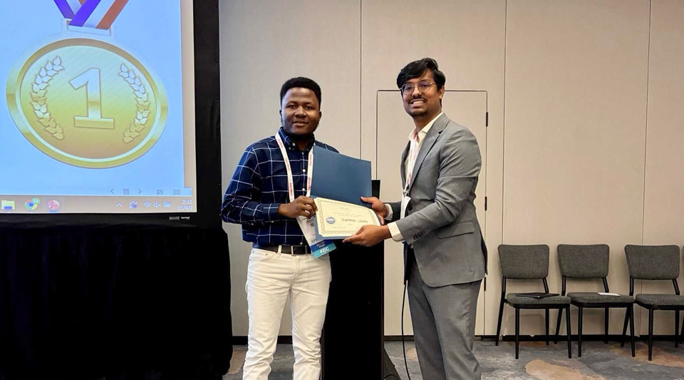 Lilonfe accepts a certificate in front of a projector screen.